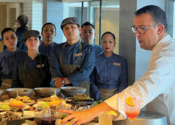 Chef Alexis Quaretti shows his staff the menu items at Aquamar Kitchen on the Marina.