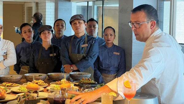 Chef Alexis Quaretti shows his staff the menu items at Aquamar Kitchen on the Marina.