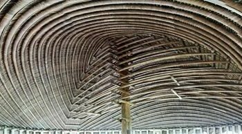 A ceiling of woven organic material in a spiral shape