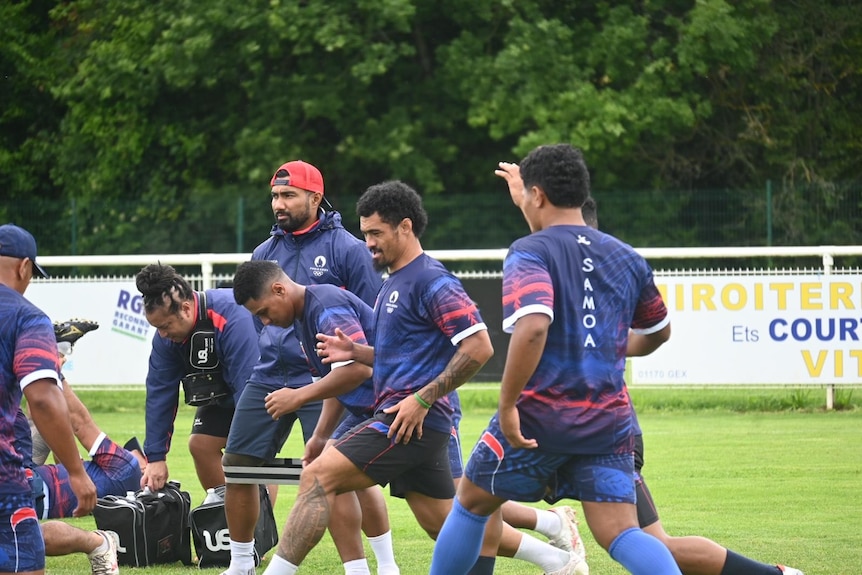 Manu Samoa players wearing navy blue training uniforms during a training run on the field 